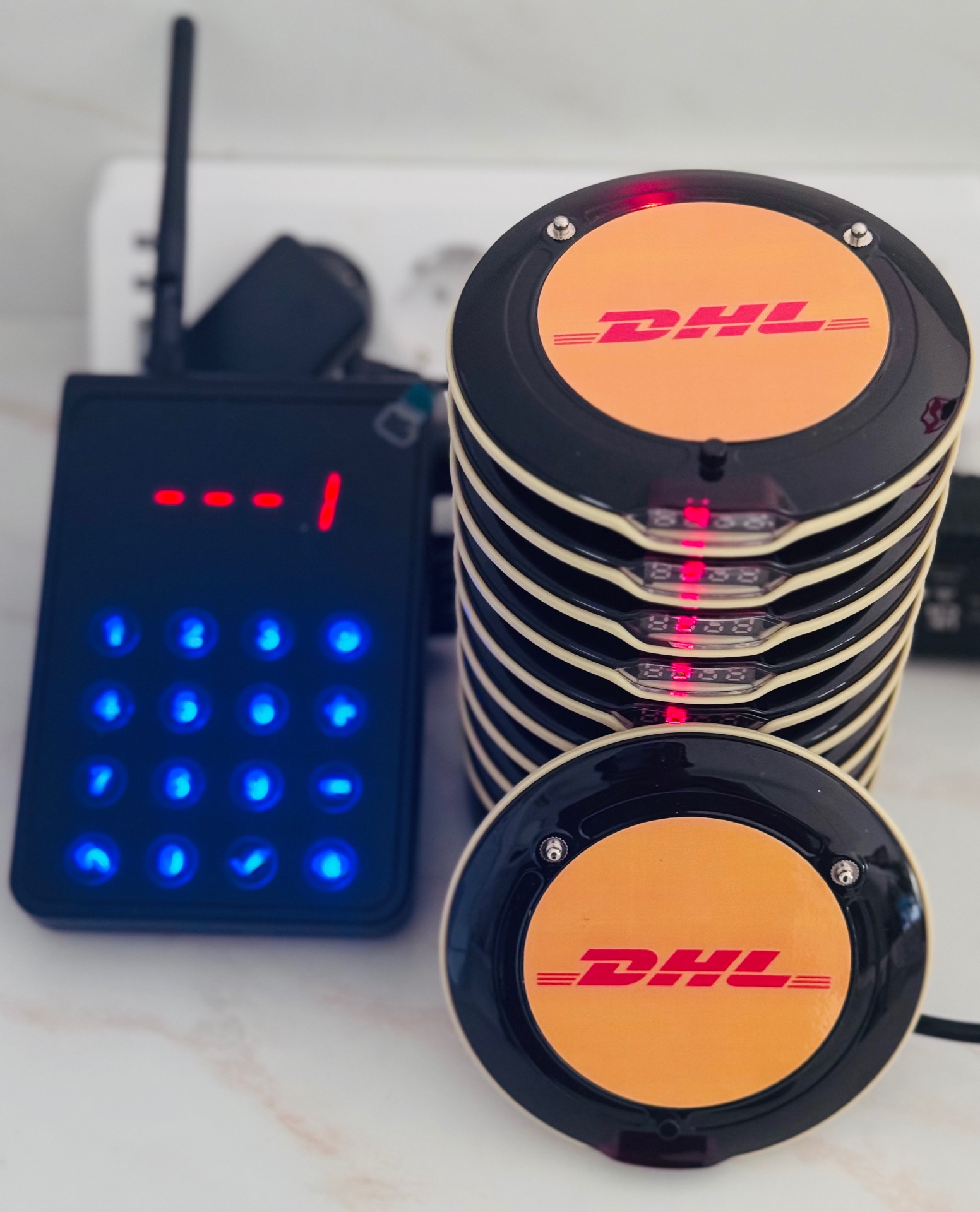 Pack de bipeurs clients personnalisés au logo DHL avec base d'appel : le numéro affiché en rouge sur la base est le numéro du bipeur appelé (et non le numéro de commande)